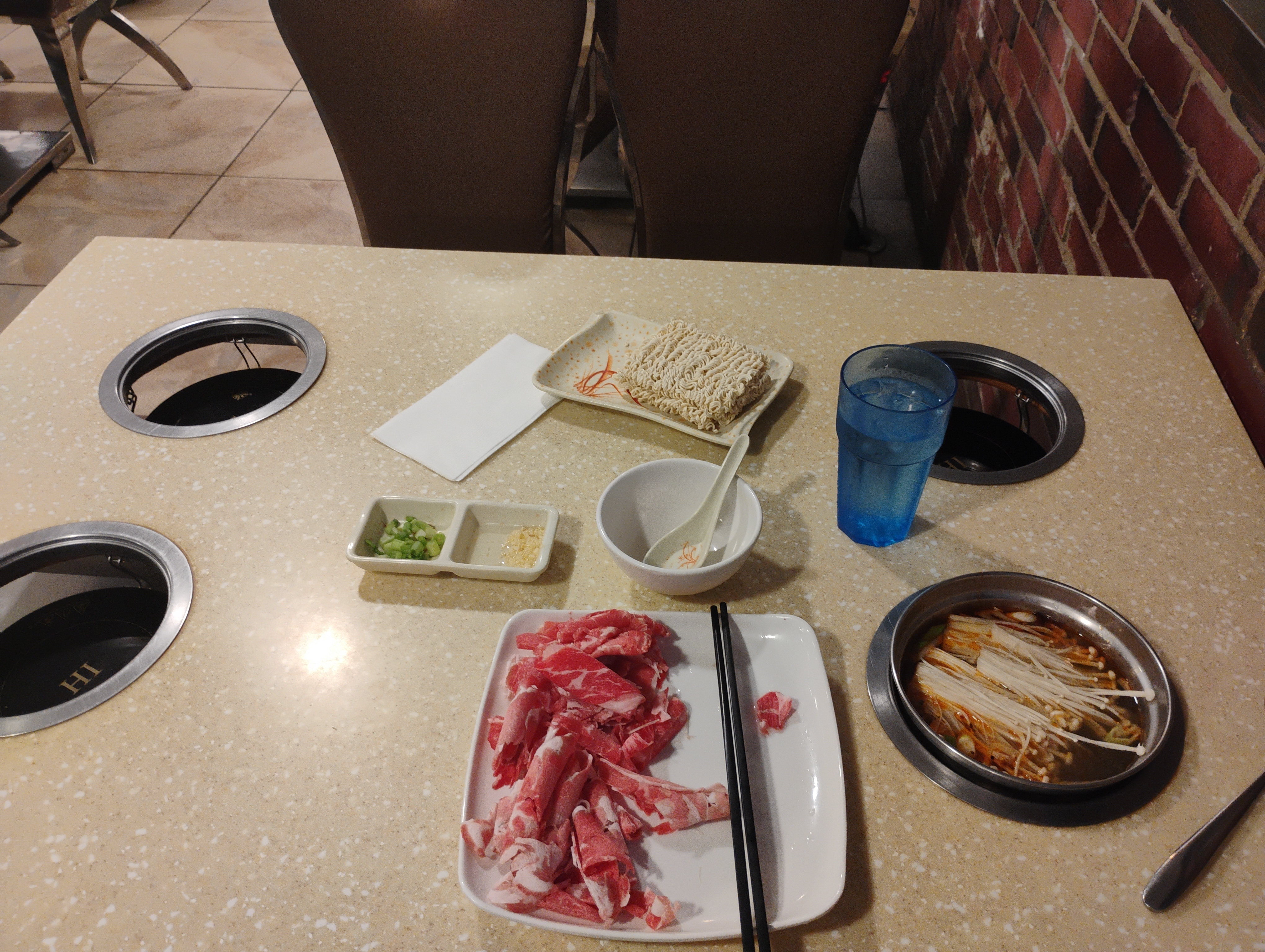 Hotpot. There is a bowl of soup on the table with four heaters.